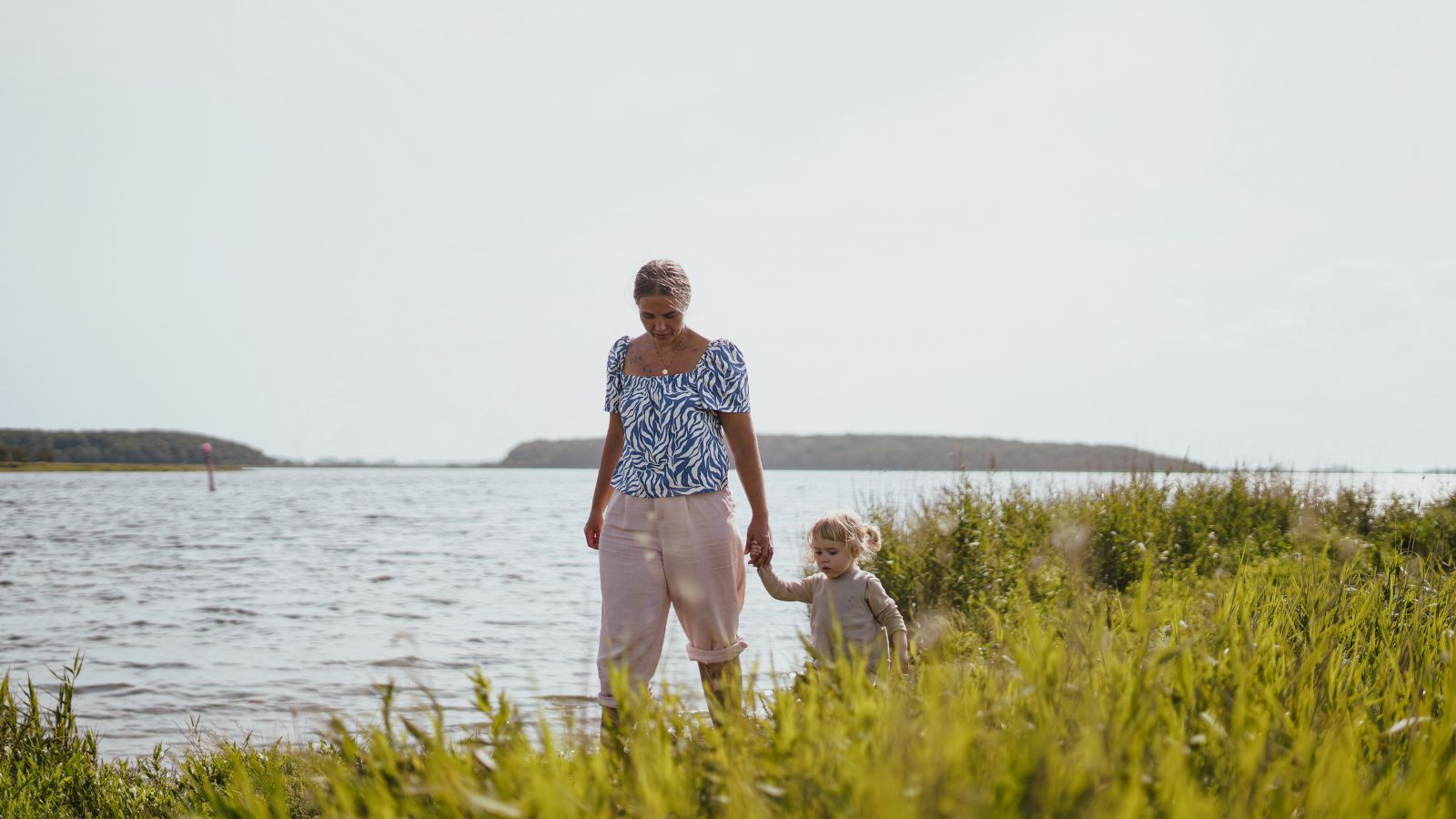 Mor og datter går ved kysten