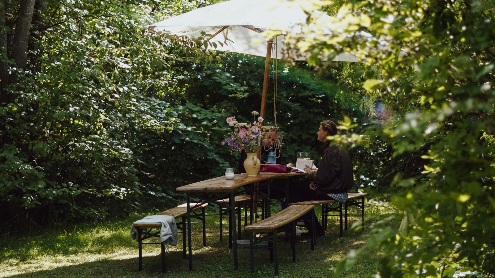 Mand sidder ved havebord på Ro Naturcamp